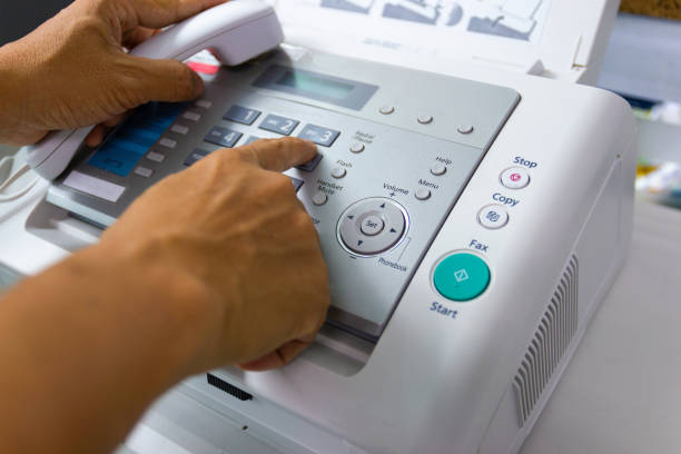 Hand Man are using a fax machine in the office stock photo