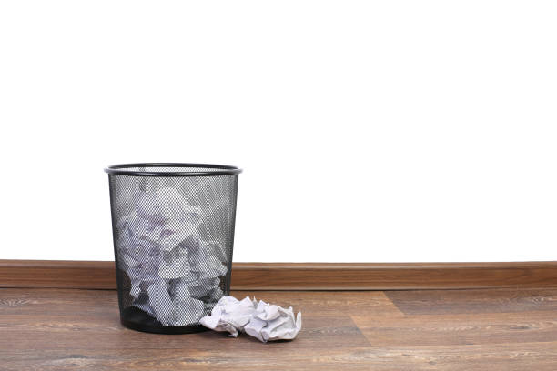 istock Trash can with papers on the floor isolated on white 955491094