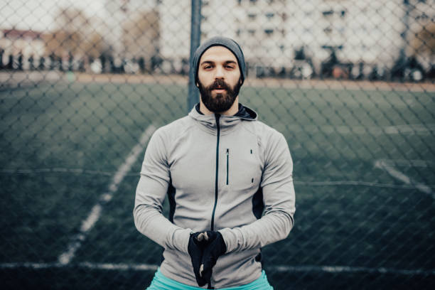 istock Young muscular man standing in front football field 955494332
