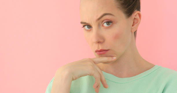 istock Pretty girl shows indignation pink background 955496302