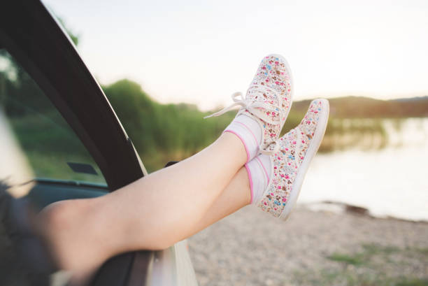 istock Woman's legs out of the car window. 955498906