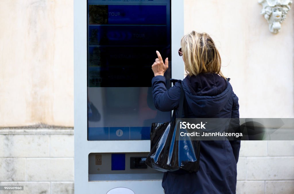 Smart City: Woman Using Interactive Digital Kiosk (Close-Up) Smart City: Woman Using Interactive Digital Kiosk (Close-Up). Copy space available at the top of the frame. Shot in Ragusa, Sicily. Digital Signage Stock Photo
