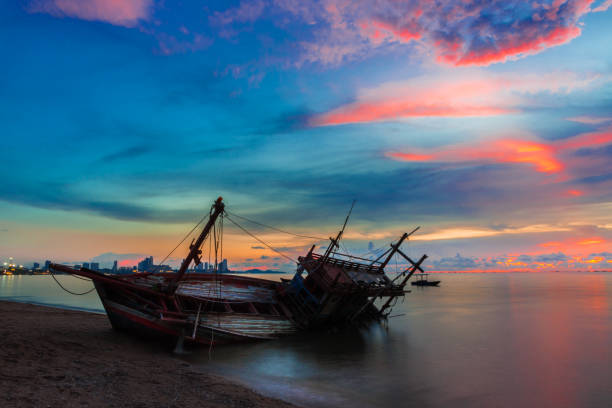 istock Wreck was left on the beach with the beautiful twilight sky. 955502410