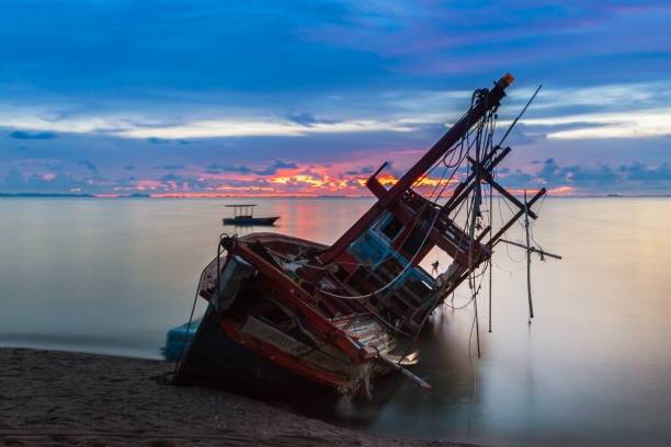 istock Wreck was left on the beach with the beautiful twilight sky. 955502420