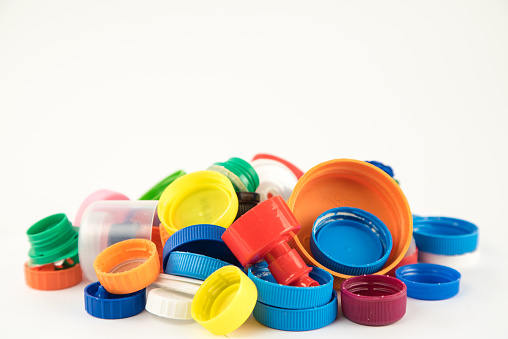 Group of multicolored bottle caps isolated on white background in studio.