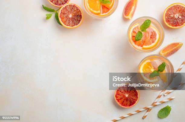 Cold Refreshing Drink With Blood Orange Slices In A Glass On A White Concrete Background Stock Photo - Download Image Now