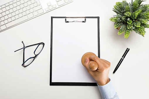 Woman stamping documents on office desk.