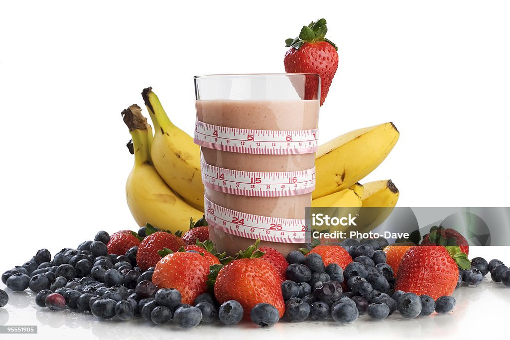 Healthy mixed fruit smoothie with measuring band Smoothie in a glass surrounded by fruit and wrapped with a tape measure  Banana Stock Photo