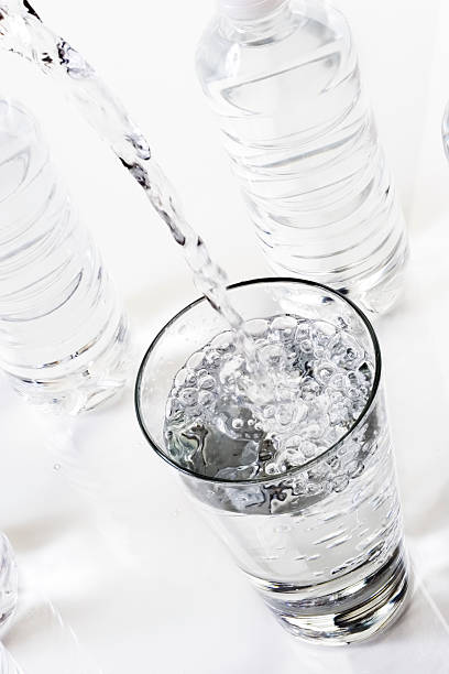 水を注ぐ、 - overflowing water glass bottle ストックフォトと画像
