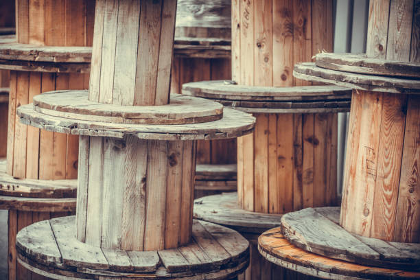 Wooden spools, cable reels, stacked up for storage in an industrial park -  a Royalty Free Stock Photo from Photocase