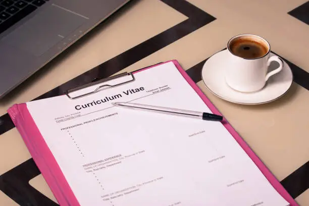 Curriculum vitae cv, laptop and a cup of fragrant coffee as a concept for job search and hiring staff.