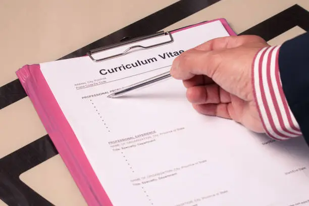 Curriculum vitae cv as a form for job search and recruitment. The man's hand indicates the form to fill the job seeker.