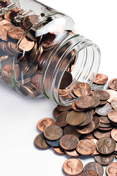 istock Jar of pennies tipped over 95553658