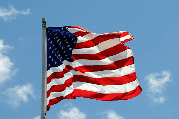 istock American Flag on Blue Cloudy Sky 95553957
