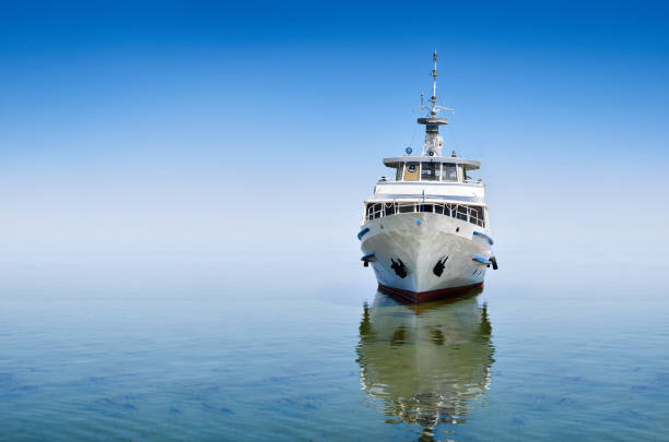 White ship on sea waves against the blue sky.