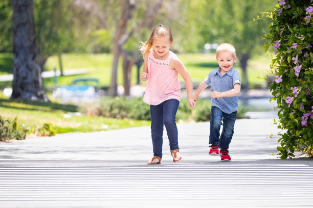 istock Young Sister and Brother Having Fun Running At The Park 955540964