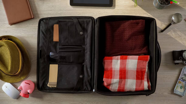 istock Necessary things neatly packed in suitcase, people going on vacation, top view 955555100