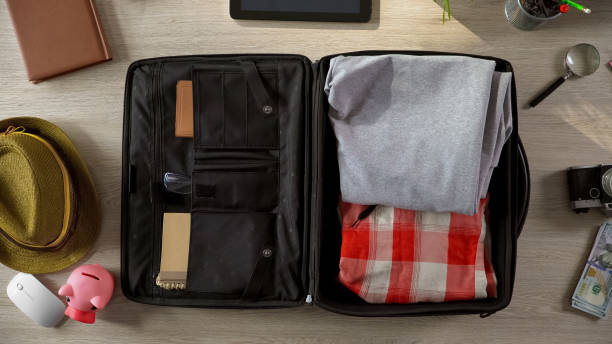 istock Things packed in suitcase on table, summer vacation, business trip, top view 955555140