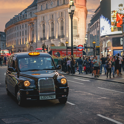 London, UK - April, 2018. View of Piccadilly Circus in central London crowded with tourists. It is one of the most visited landmarks with its iconic billboards, double-decker buses and taxis. Square format.