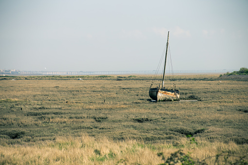 a rusting boat on low tidal grounds in Essex, UK