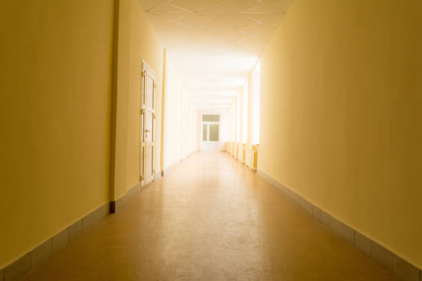 istock long dark corridor with bright light from windows, light at the end of corridor 955569458