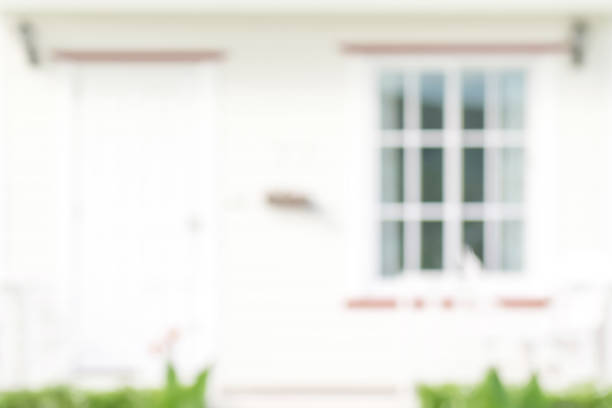 Front view of cozy white house with door and window - abstract  blurred background