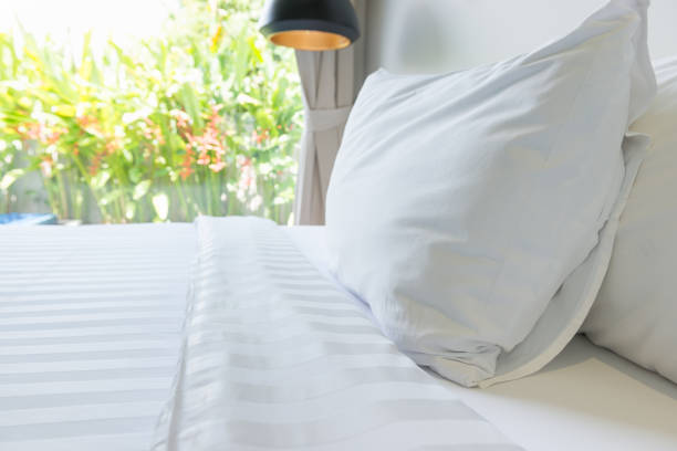 istock White pillow and white bed in bed room 955579004