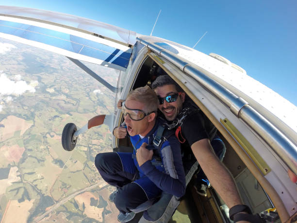 tandem paracadutismo sulla porta - skydiving parachuting extreme sports airplane foto e immagini stock