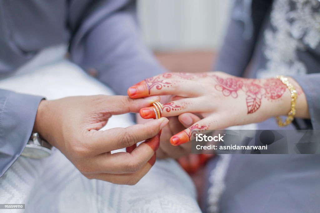Pengantin pria meletakkan cincin kawin di tangan pengantin - Bebas Royalti Islam Foto Stok Pengantin pria meletakkan cincin kawin di tangan pengantin - Bebas Royalti Islam Foto Stok
