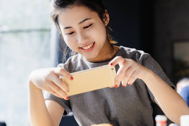 istock Asian girl using smart phone at cafe,Shanghai,China 955607298