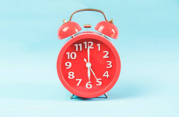 Alarm clock at 6.00am/pm. isolated on blue pastel background