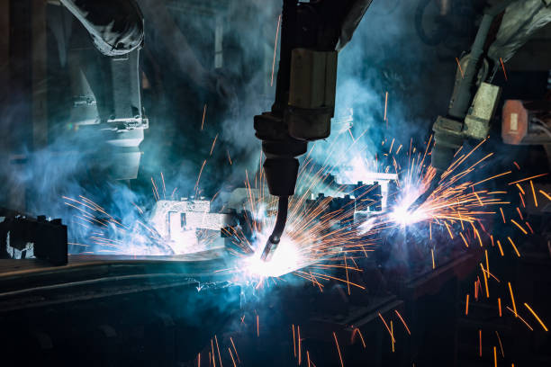 istock Close up team robots are welding in factory 955612048