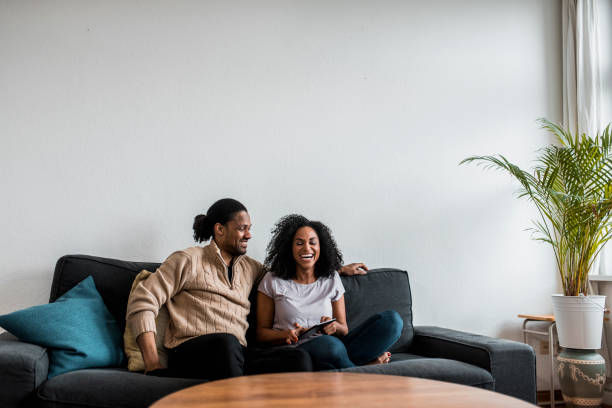 istock Couple sitting on the sofa talking and laughing 955624380