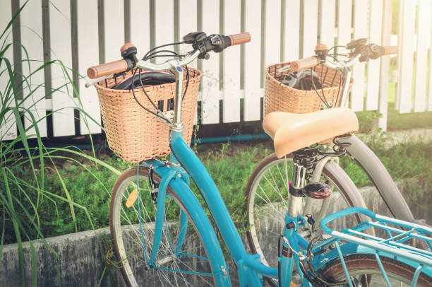 Two retro bikes parked near village white fence