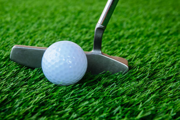 istock Golfer putting golf ball on green 955628870