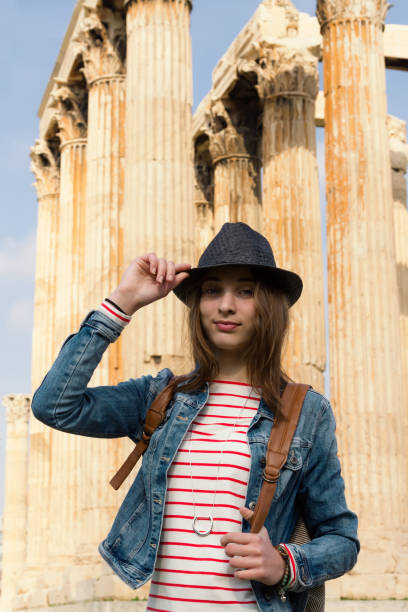 jovem viajante feminino em volta. colunas de plano de fundo do famoso templo de zeus em atenas. - monument athens greece people travel - fotografias e filmes do acervo