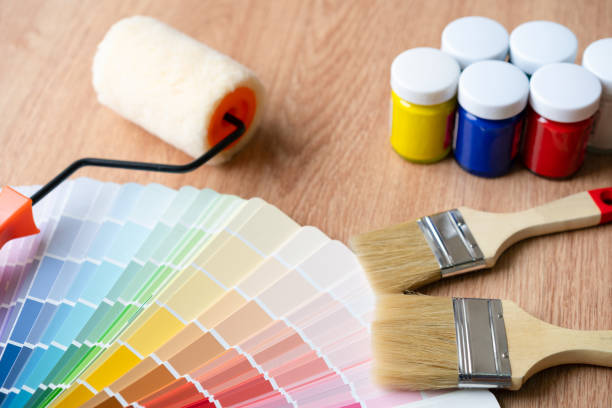 istock Painter and decorator work table with house project, Color swatches, Painting roller and paint brushes 955645694