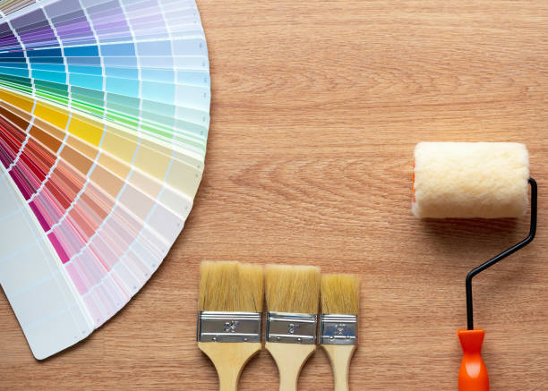 istock Painter and decorator work table with house project, Color swatches, Painting roller and paint brushes 955645696