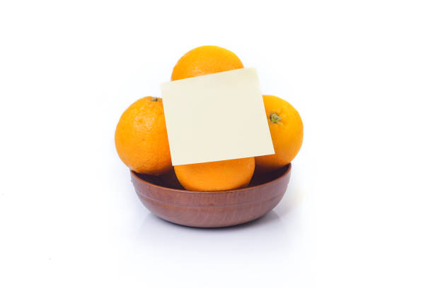 Basket of oranges isolated on white background with yellow sticky note
