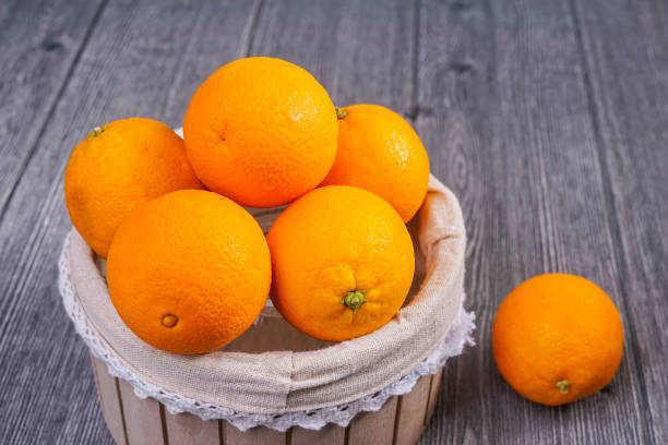 istock Basket of oranges on wooden background. 955649130