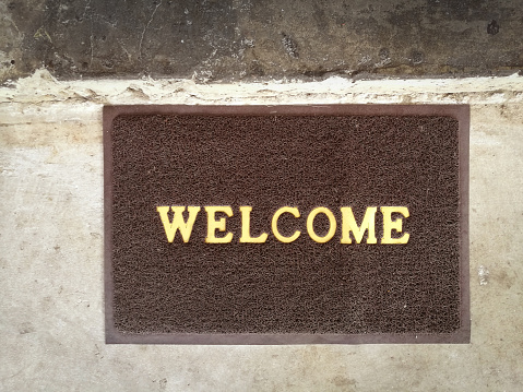 Welcome carpet on old cement floor vintage background