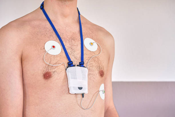 uomo che indossa un dispositivo di monitoraggio elettrocardiogramma di 24 ore sul petto - pulse trace computer monitor eeg equipment foto e immagini stock