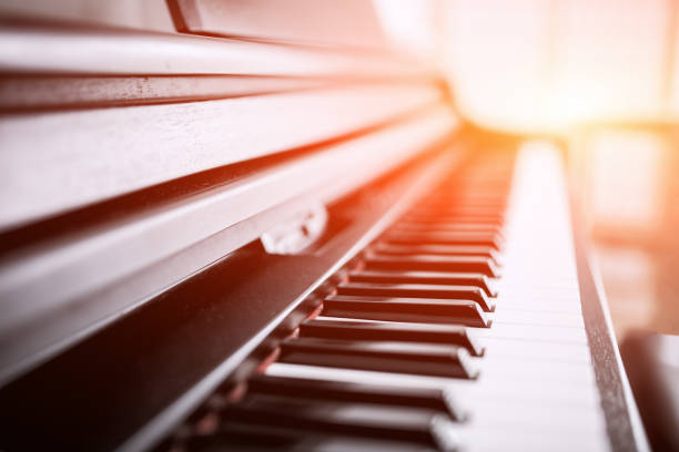 Piano keyboard background with selective focus. Warm color toned image