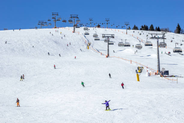 istock People Skiing On Hill With Ski Lift 955660696