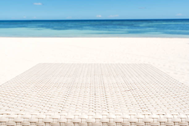 istock Wood weave table surface and sunny beach background 955664334