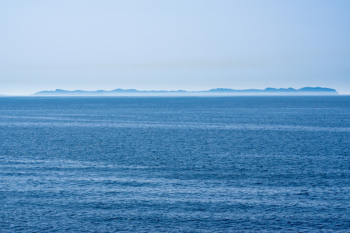 Seascape of the Mediterranean Sea, from the coastline of Cala Pi (southern coast of Mallorca), looking towards the outline of Cabrera Island on the horizon.  

Cabrera Island was designated a Maritime Terrestrial National Park in 1991. It is located 11 miles off the coast.