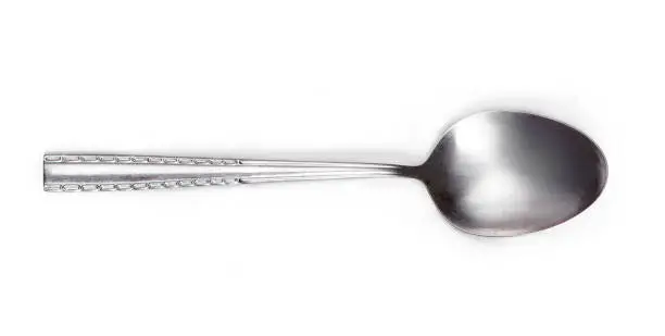 Steel tablespoon. Dinning silver spoon isolated on white background. Kitchen utensils concept, close up"n