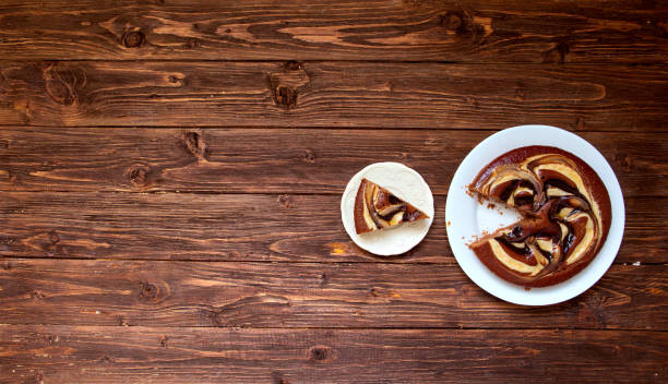 Chocolate cake and piece of chocolate cake on wooden background. Top view with copy space