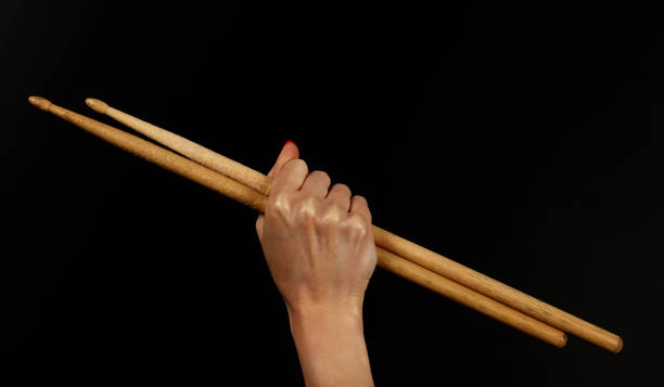 istock Close up woman hand with drumsticks over black 955681616