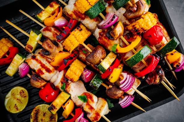 istock Grilled vegetable and chicken skewers on a grill pan, top view 955682744
